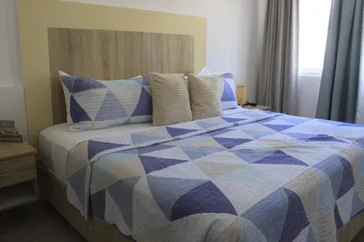 a bedroom with a blue and white bed with pillows at Depto entero, Coral Village D204, WIFI, TV, cerca de la playa in Punta Cana