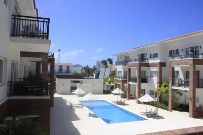 a swimming pool in front of a building at Depto entero, Coral Village D204, WIFI, TV, cerca de la playa in Punta Cana