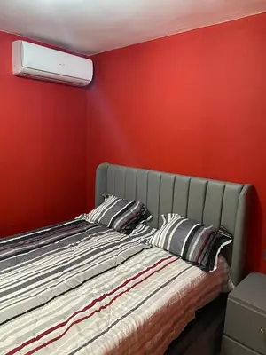 a bedroom with a bed with a red wall at 1st floor 3 Bedrm 2 Baths AC Condo near airport in Los Paredones