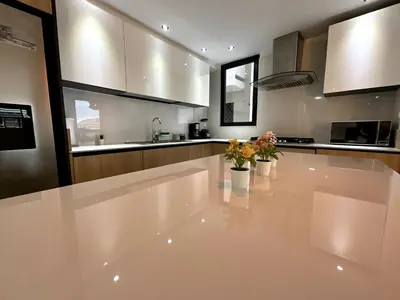 a large white kitchen with flowers on the counter at Comfortable Central Apartment in Santo Domingo