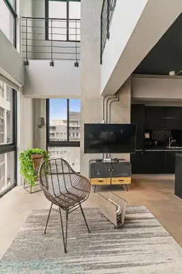 a living room with a chair and a television at PH Loft, 3floors,Private Jacuzzi n terrace,Kingbed in Santo Domingo