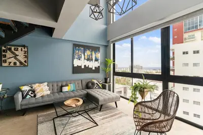 a living room with a couch and a large window at PH Loft, 3floors,Private Jacuzzi n terrace,Kingbed in Santo Domingo