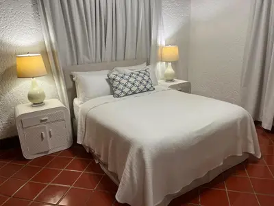 a bedroom with a white bed and two lamps at Casa de Campo Tenis Villa 16 in La Romana