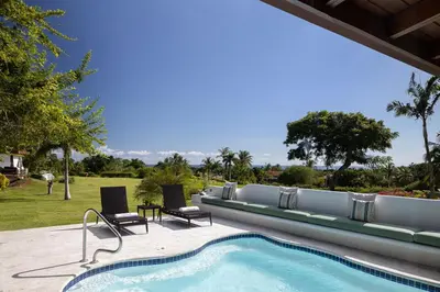 a swimming pool with two lounge chairs next to a resort at Casa de Campo Tenis Villa 16 in La Romana