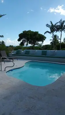a swimming pool with blue water in a resort at Casa de Campo Tenis Villa 16 in La Romana