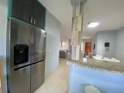 a kitchen with a stainless steel refrigerator and a sink at Amazing apartment pool and beach life in los corals punta cana in Punta Cana