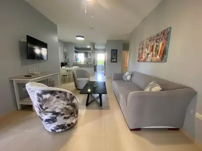 a living room with a couch and a table at Amazing apartment pool and beach life in los corals punta cana in Punta Cana