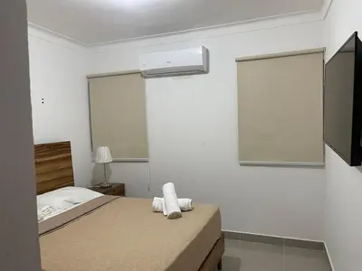 a bedroom with a bed and a air conditioner at Modern Apt in Santiago w Pool, 3 Bedrooms, Air conditioner in Santiago de los Caballeros