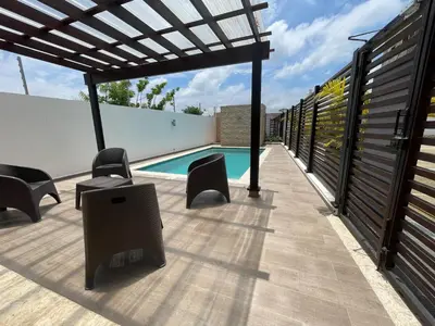 a patio with chairs and a swimming pool at Modern Apt in Santiago w Pool, 3 Bedrooms, Air conditioner in Santiago de los Caballeros