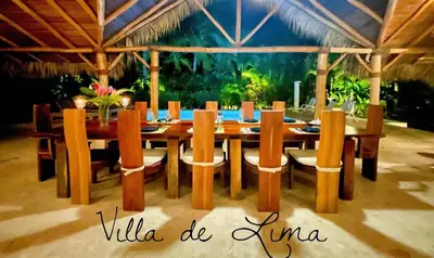 a wooden dining table and chairs in a restaurant at Villa de Lima in Las Terrenas