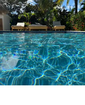 a swimming pool with blue water with chairs in it at Villa de Lima in Las Terrenas