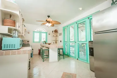 a kitchen with green shutters and a ceiling fan at La Dolce Vita in Las Terrenas