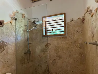 a bathroom with a glass shower with a window at Villa La Palmeras - 8 Pax, 5 min de La Playa in Las Galeras