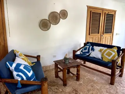 a living room with two blue chairs and a table at Villa La Palmeras - 8 Pax, 5 min de La Playa in Las Galeras
