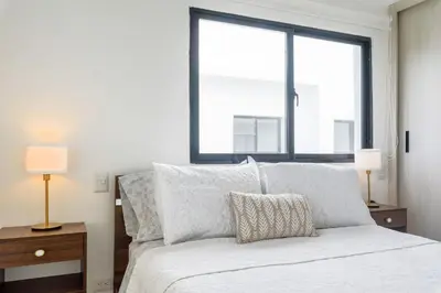 a bedroom with a bed with two lamps and a window at Penthouse con picuzzi privado y barbacoa en Bávaro in Punta Cana