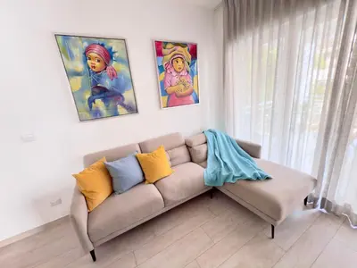 a couch in a living room with paintings on the wall at Casa Mulata Paseo del Mar 2 Pool & Playa in Punta Cana