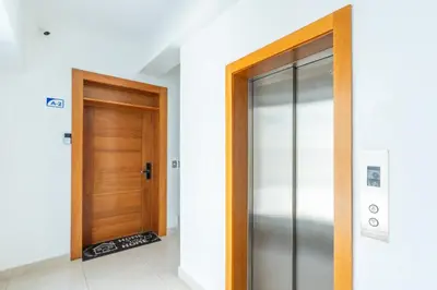 a hallway with a wooden door in a building at Modern Oasis near Monument with Rooftop BBQ , Gym, and Free Parking in Santiago de los Caballeros