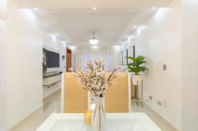 a vase with flowers on a table in a room at Modern Oasis near Monument with Rooftop BBQ , Gym, and Free Parking in Santiago de los Caballeros