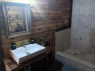 a bathroom with a white sink and a shower at 1Vida Bar Restaurante in Guayacanes