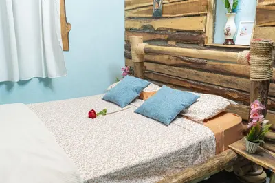 a bed with two pillows on it in a room at 1Vida Bar Restaurante in Guayacanes