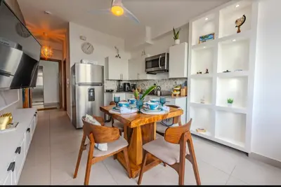 a kitchen with a wooden table and chairs in a room at Ventanas del mar in Los Corrales
