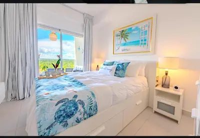 a white bedroom with a bed with a turtle on it at Ventanas del mar in Los Corrales