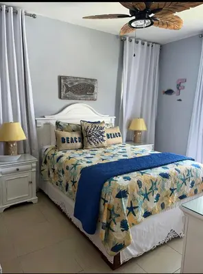 a bedroom with a bed with a blue comforter and two lamps at Cadaqués best sunset in La Fragata