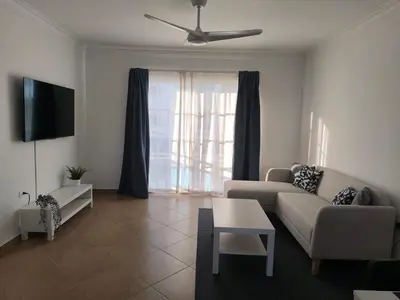 a living room with a couch and a tv at Cana Esmeralda in Punta Cana