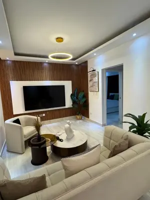 a living room with a white couch and a tv at Andrea Victoria in Santo Domingo