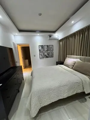a bedroom with a large bed and a flat screen tv at Andrea Victoria in Santo Domingo