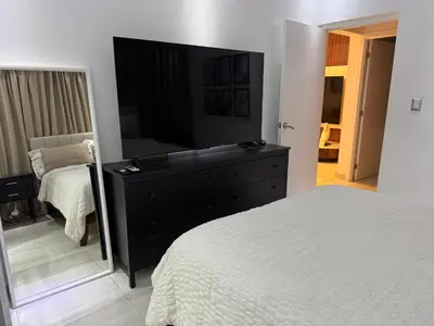 a bedroom with a bed and a dresser with a mirror at Andrea Victoria in Santo Domingo