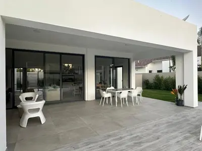 a patio with chairs and a table in a house at VILLA CORAL Tracadero Beach Resort in La Laguna