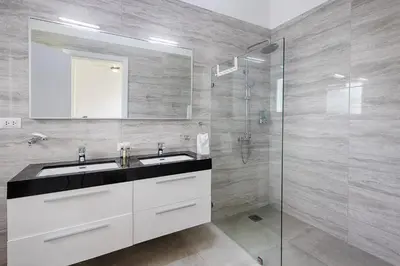 a bathroom with a sink and a glass shower at VILLA CORAL Tracadero Beach Resort in La Laguna