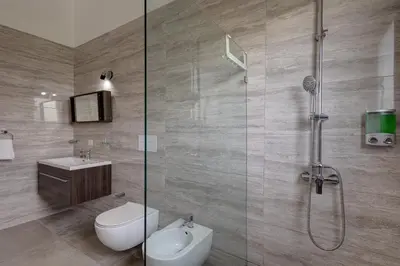 a bathroom with a shower and a toilet and a sink at VILLA CORAL Tracadero Beach Resort in La Laguna