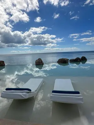 two beds in the ocean with rocks in the water at VILLA CORAL Tracadero Beach Resort in La Laguna
