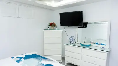 a bedroom with a bed and a dresser with a flat screen tv at Villa Rosa Boca Chica in Boca Chica