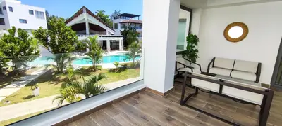a balcony with a bench and a view of a pool at AMAR'E beach front apartment overlooking pool in Las Terrenas