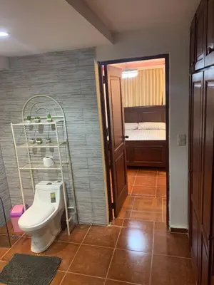 a bathroom with a toilet in a room with a bed at Essential Life La Cuaba Casa de Campo Amenities in Pedro Brand