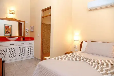a bedroom with a bed and a bathroom with a sink at Central Hotel Boutique in Las Galeras