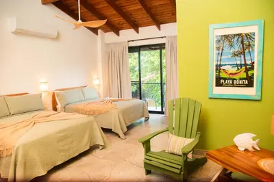 a bedroom with two beds and a chair and a table at Central Hotel Boutique in Las Galeras