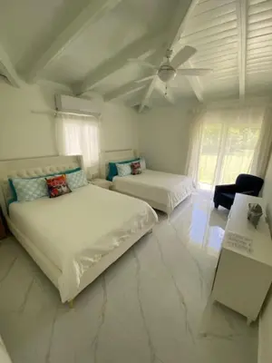 a white room with two beds and a couch at Villa Allegria Los Lagos 57 in La Romana