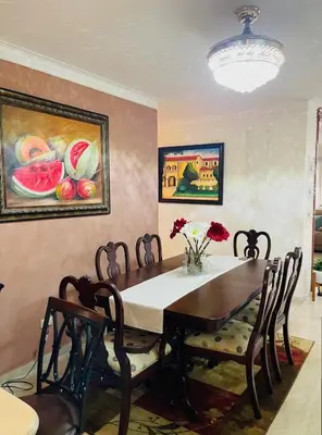 a dining room table with chairs and a vase of flowers at FreshBreeze - Apartment Near US Embassy in Santo Domingo