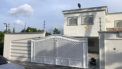 a white gate in front of a white house at Villa Gordon in Santa Cruz de Barahona