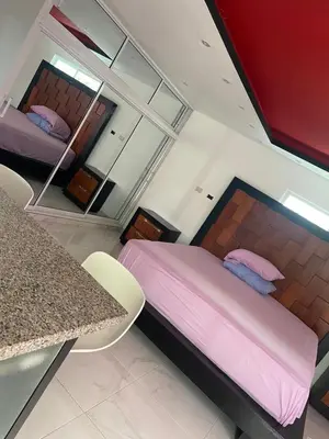 a bedroom with a bed and a table and a mirror at Villa anastacia in Sabaneta de Yásica