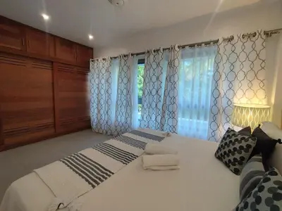 a bedroom with a large white bed with curtains at Comfort one step away from the beach in Las Terrenas
