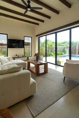 a living room with a couch and a tv and windows at Casa Sharon in El Valle