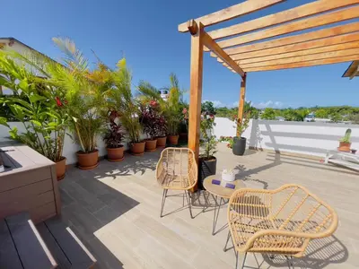 a patio with chairs and plants on a roof at 3BR & Rooftop Jacuzzi Near Beach in Las Terrenas