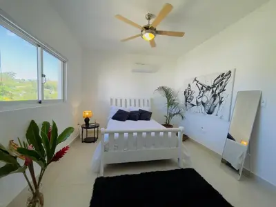 a white bedroom with a bed and a ceiling fan at 3BR & Rooftop Jacuzzi Near Beach in Las Terrenas