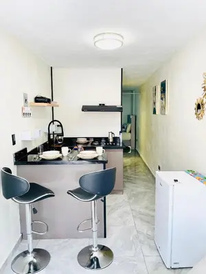 a kitchen with a counter and two bar stools at cerca de los mejores restaurantes I TV l Wifi in Constanza