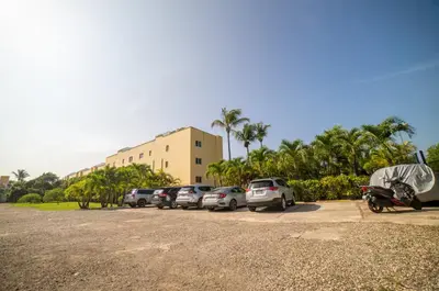 a parking lot with cars parked in front of a building at Garden Condo, Sosua in Sosúa